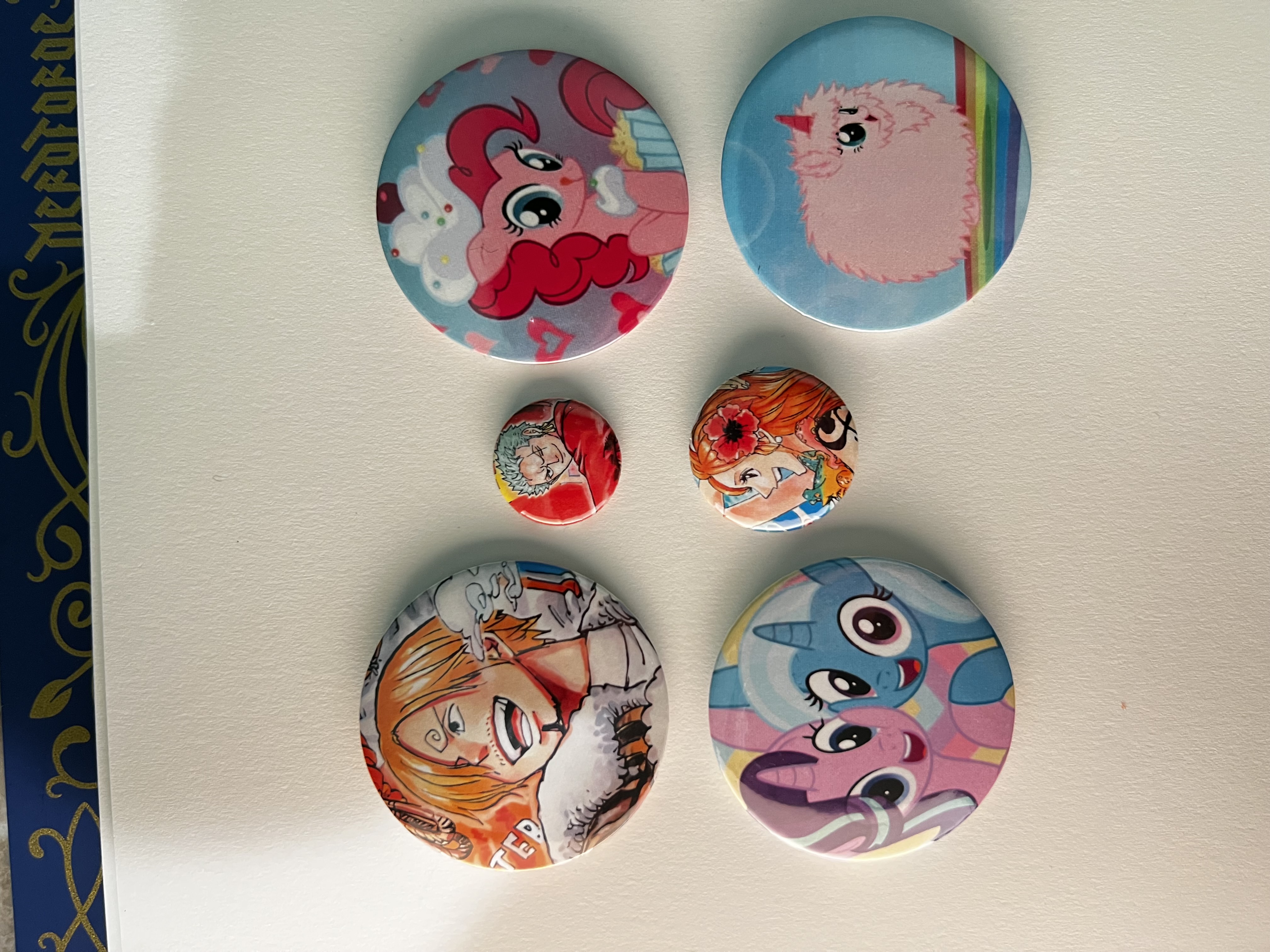 A colorful collection of handmade pin-back buttons created by Star